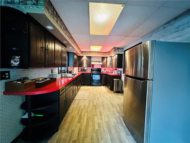 121 E William St, Bath, NY 14810 - kitchen with light wood finished floors, a sink, dark countertops, wall chimney exhaust hood, and stainless steel appliances