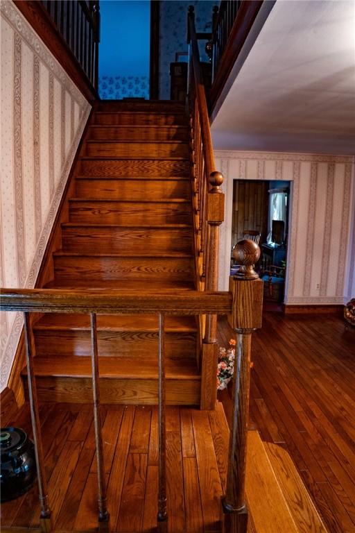 stairs featuring wallpapered walls and hardwood / wood-style floors