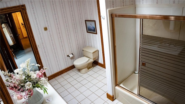 bathroom with toilet, wallpapered walls, a shower with shower door, tile patterned floors, and baseboards