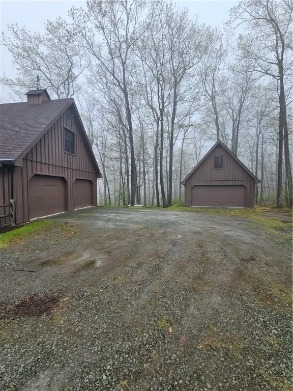 detached garage featuring dirt driveway