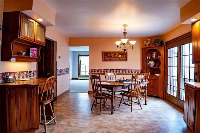 dining room with baseboards and a notable chandelier
