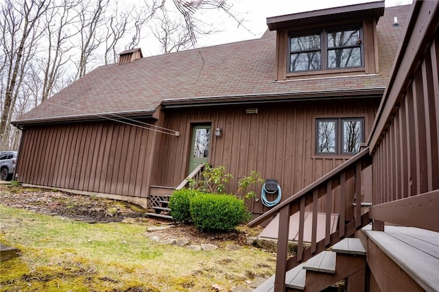 property entrance featuring roof with shingles and a chimney