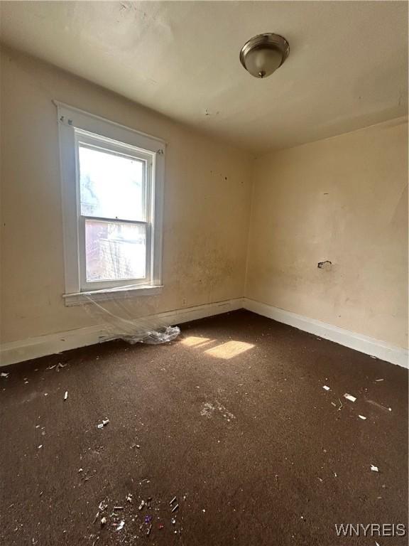 spare room with baseboards