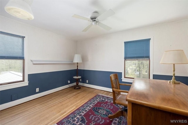 office featuring baseboards, ceiling fan, plenty of natural light, and wood finished floors