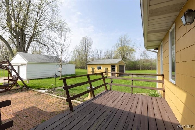 wooden deck featuring an outbuilding and a lawn