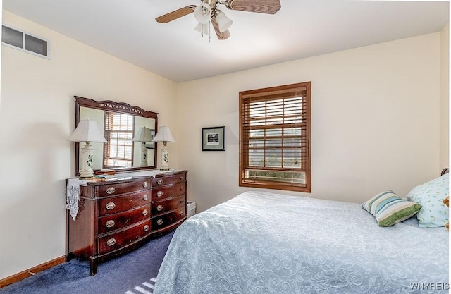 bedroom featuring baseboards, dark carpet, multiple windows, and visible vents