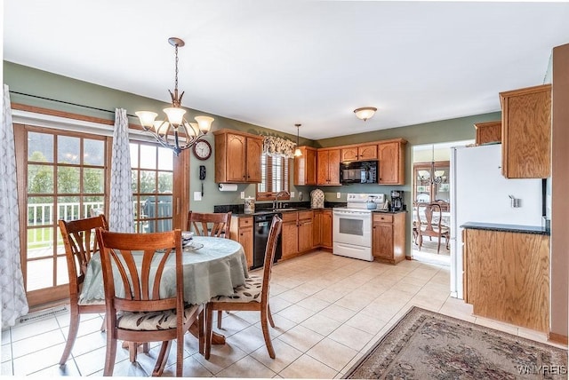 kitchen with dark countertops, a chandelier, decorative light fixtures, and black appliances