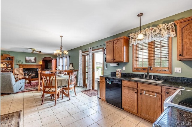 kitchen featuring decorative light fixtures, dishwasher, a sink, ceiling fan with notable chandelier, and a fireplace