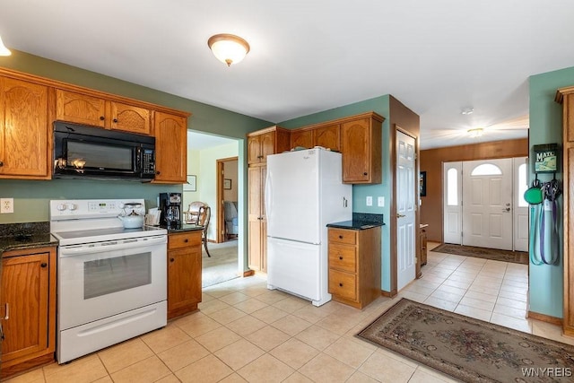 kitchen with brown cabinetry, white appliances, and light tile patterned flooring