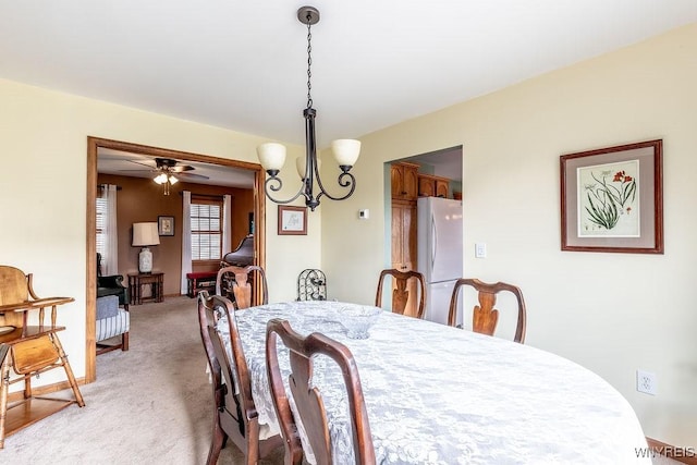 dining room with a chandelier and light carpet