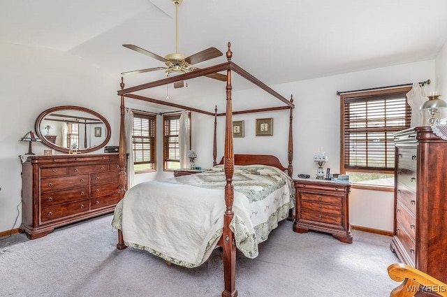 bedroom featuring light colored carpet, lofted ceiling, and baseboards