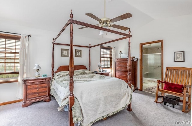 carpeted bedroom featuring a ceiling fan, ensuite bath, baseboards, and lofted ceiling