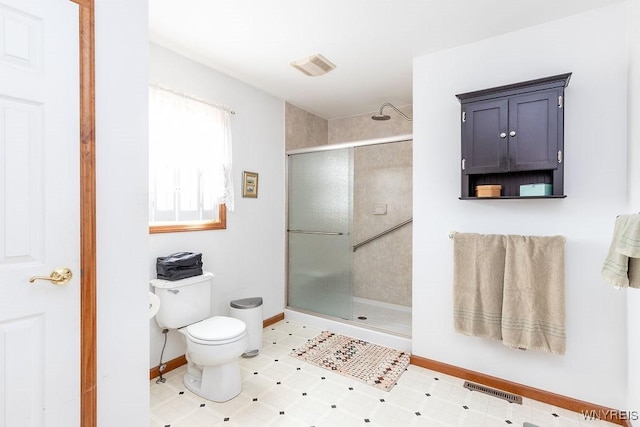 bathroom featuring a shower stall, toilet, baseboards, and visible vents
