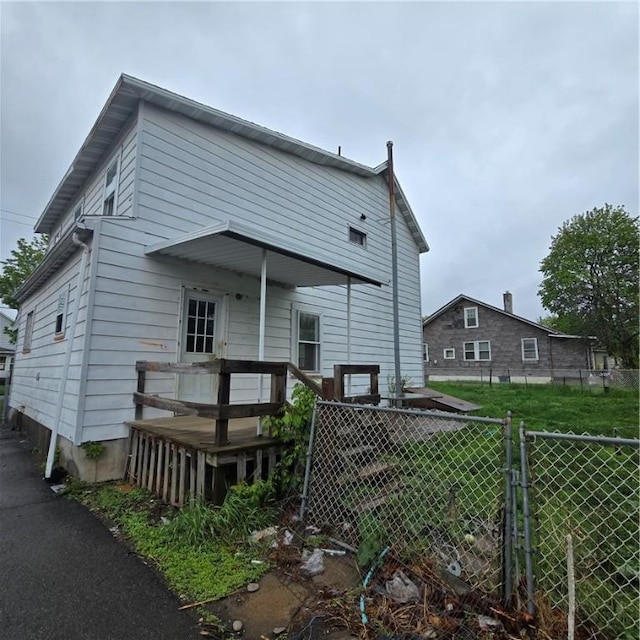 back of property with fence and a deck