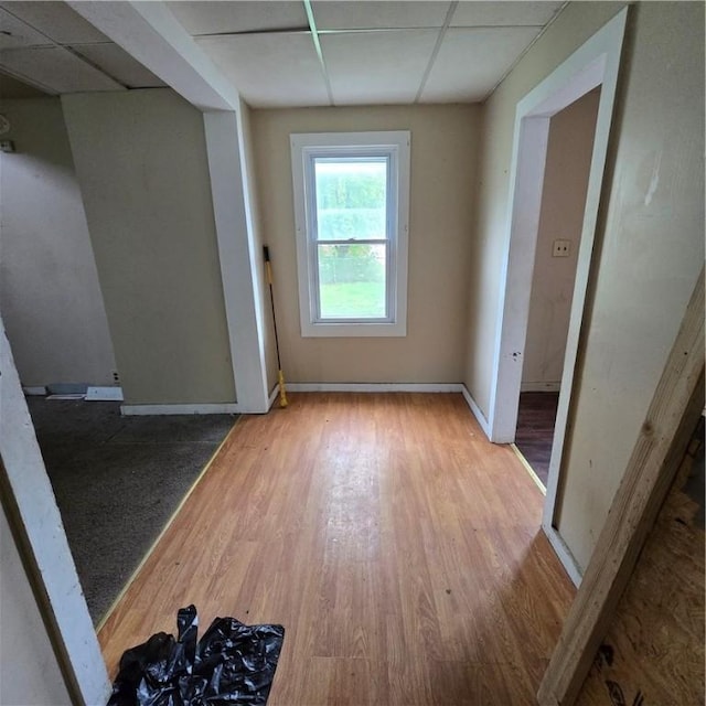 unfurnished room featuring a paneled ceiling, baseboards, and wood finished floors