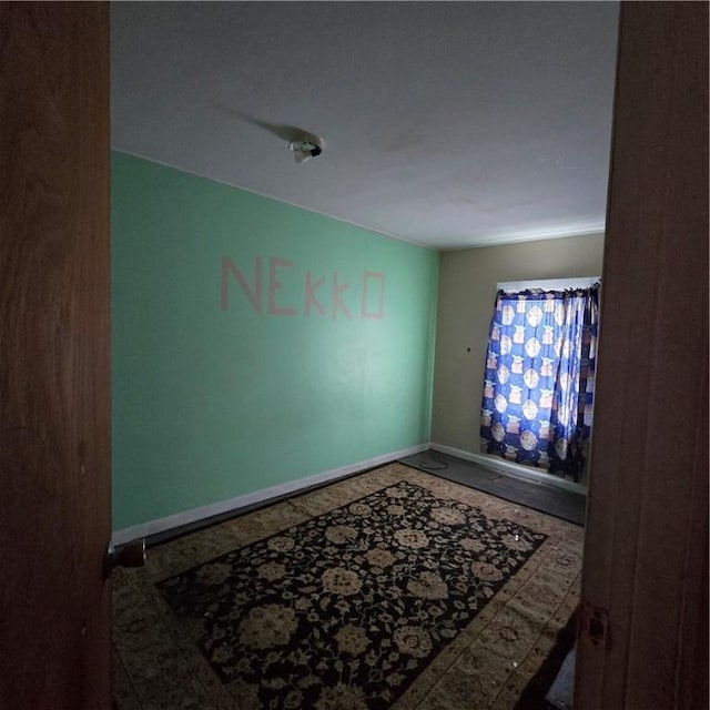 unfurnished room with baseboards