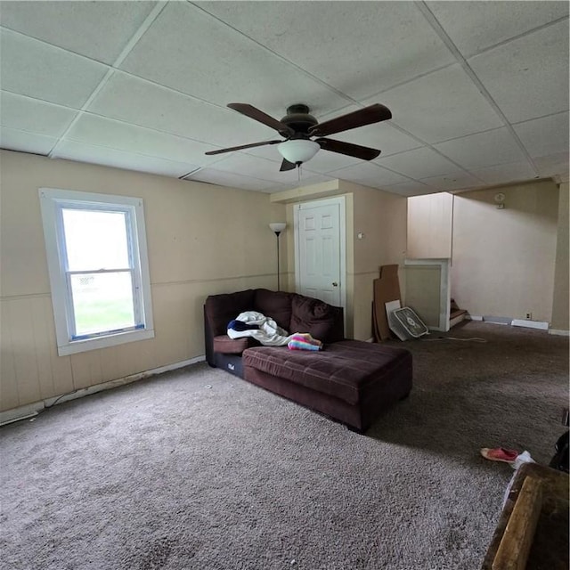 carpeted living room with a ceiling fan and a paneled ceiling