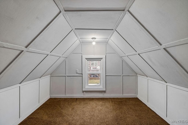 bonus room featuring vaulted ceiling, carpet flooring, and a decorative wall
