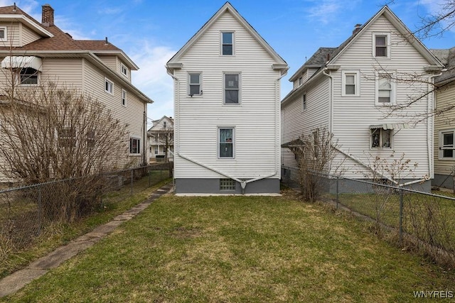 rear view of property with a lawn and a fenced backyard