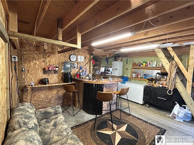 9642 S Dayton Silver Creek Rd, Villenova, NY 14062 - bar with freestanding refrigerator, a bar, refrigerator, and unfinished concrete floors
