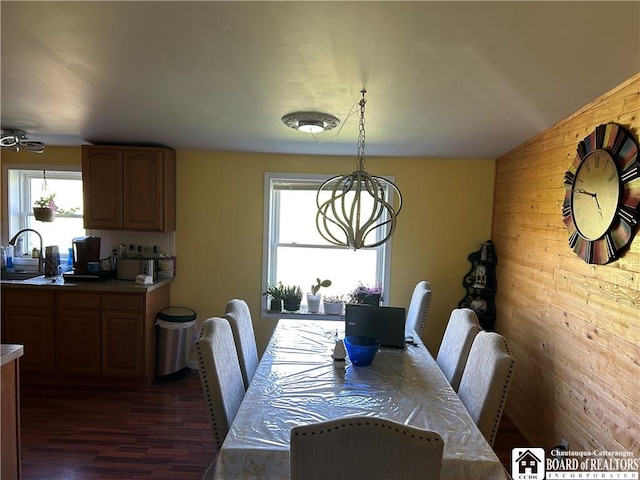 9642 S Dayton Silver Creek Rd, Villenova, NY 14062 - dining area featuring wood walls, an inviting chandelier, and dark wood-style floors