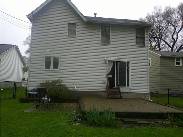 back of property featuring a lawn, fence, a deck, and entry steps