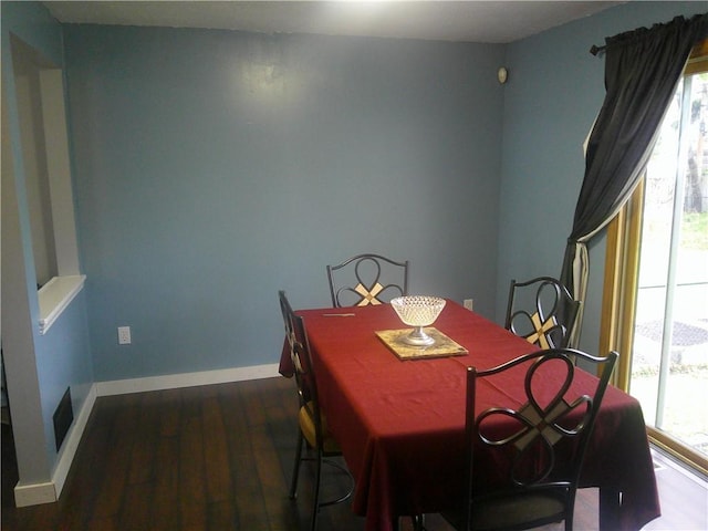 dining area with baseboards, a healthy amount of sunlight, and dark wood finished floors