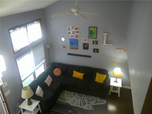 living area with baseboards, ceiling fan, and wood finished floors