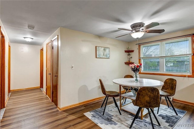 dining area with baseboards, a ceiling fan, and wood finished floors