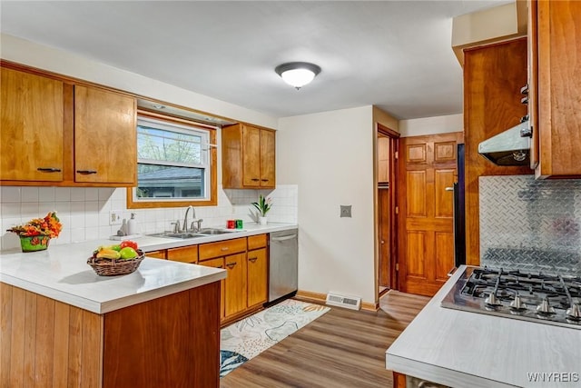 kitchen featuring backsplash, appliances with stainless steel finishes, visible vents, and a sink