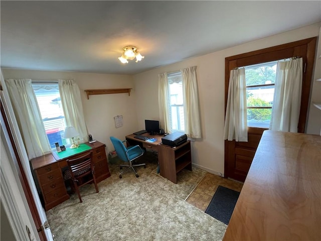 office with tile patterned floors and a healthy amount of sunlight