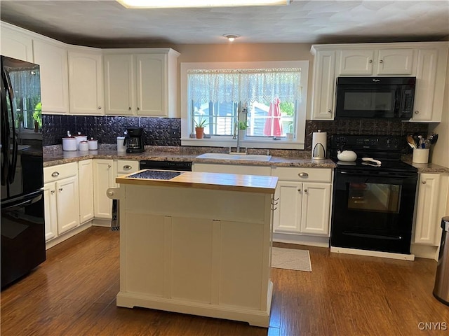 kitchen featuring white cabinets, decorative backsplash, and black appliances