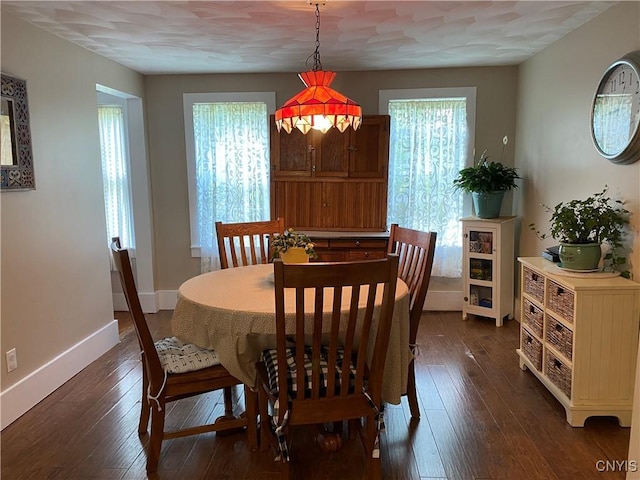 dining room with dark wood-style flooring and baseboards