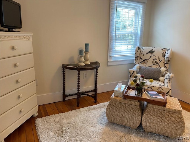 living area with baseboards and wood finished floors