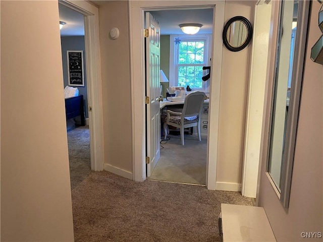 hallway with baseboards and carpet flooring