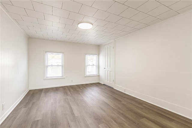 empty room with dark wood-style flooring and baseboards