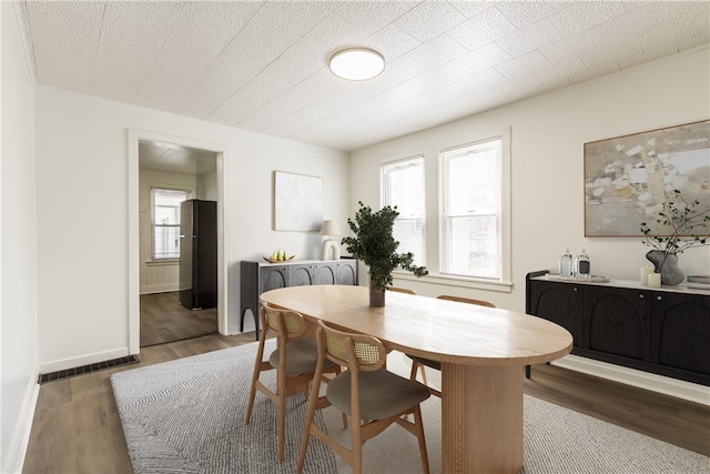 dining room featuring baseboards, visible vents, and light wood-style floors