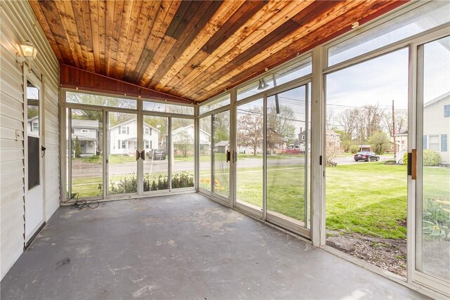 unfurnished sunroom featuring a healthy amount of sunlight and a residential view