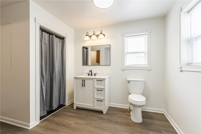 bathroom with vanity, toilet, baseboards, and wood finished floors