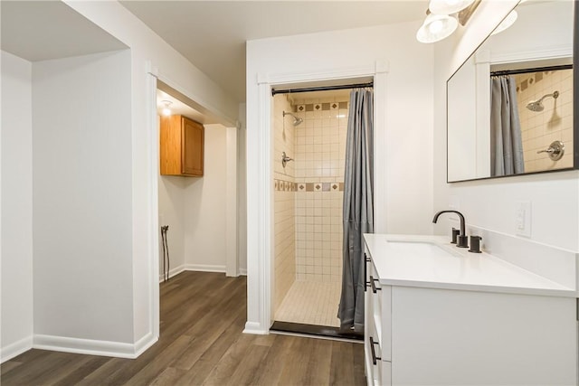 full bathroom featuring a shower stall, baseboards, vanity, and wood finished floors
