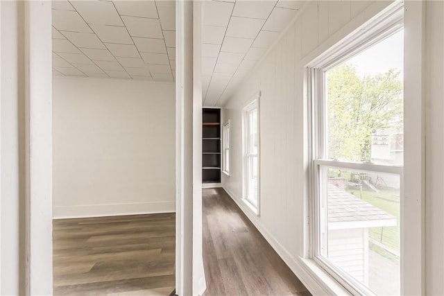 hall featuring wood finished floors and baseboards