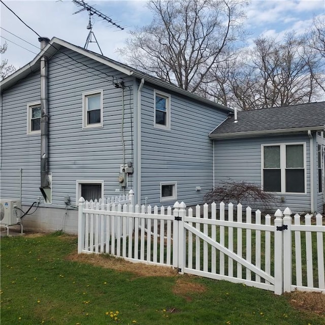 view of side of home with a yard, fence private yard, and ac unit