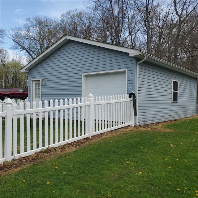 view of home's exterior featuring fence private yard, a garage, and a lawn