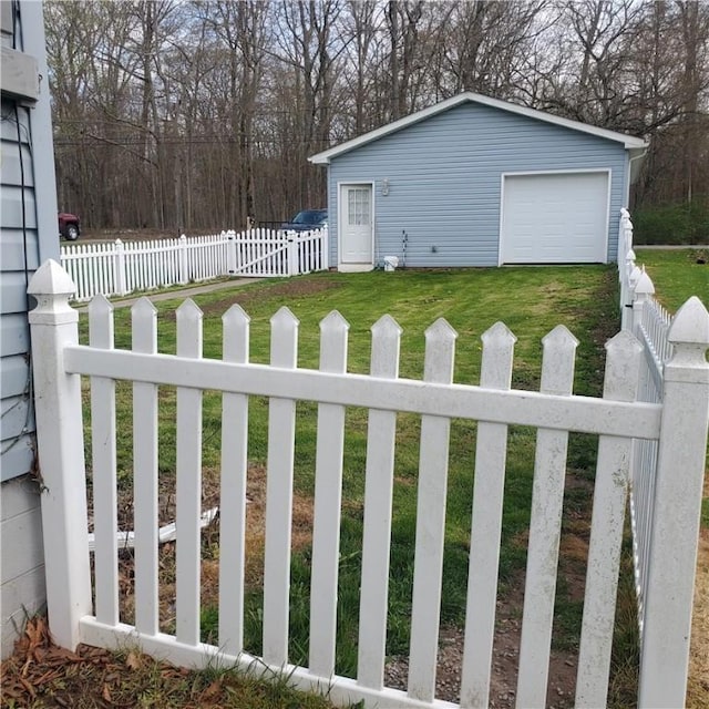 view of yard featuring driveway, an outdoor structure, a garage, and fence private yard