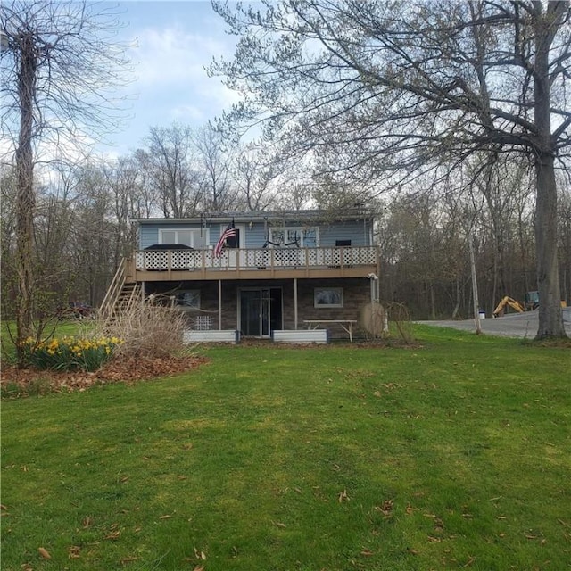 rear view of property with a wooden deck and a lawn