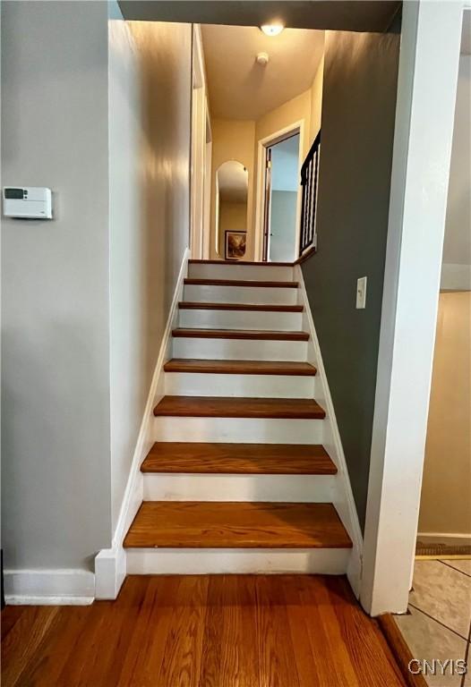 stairs with wood finished floors and baseboards