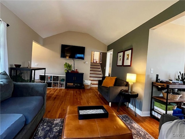 living room featuring stairway, vaulted ceiling, and wood finished floors