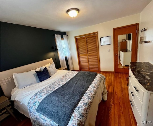 bedroom featuring a closet, wood finished floors, and baseboards