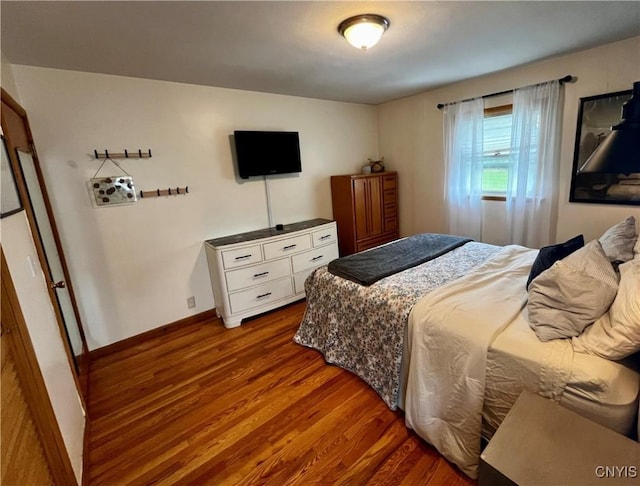 bedroom featuring baseboards and wood finished floors
