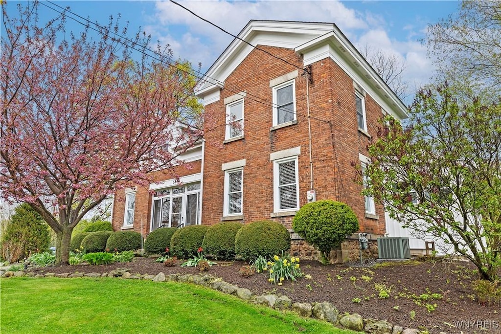 5843 Baer Rd, Cambria, NY 14132 - view of side of home with central AC unit, brick siding, and a lawn